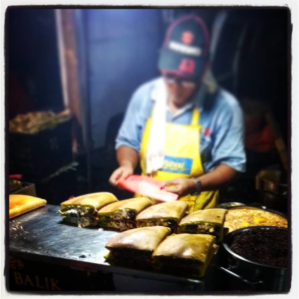 A vendor cooking at a pasar malam night market in Kuala Lumpur