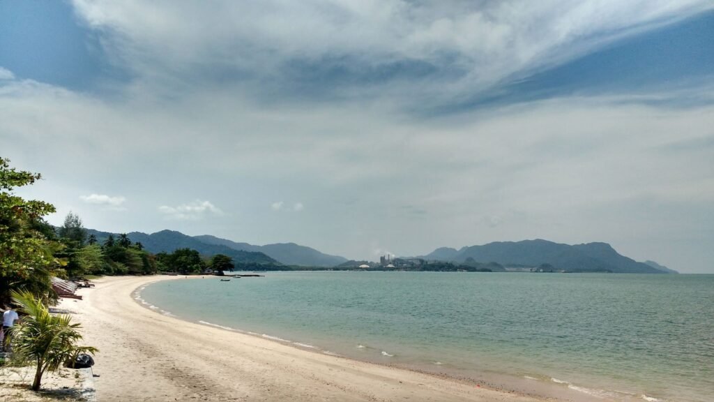 A quiet beach on Langkawi, Malaysia — pale sand, clear water and palm trees