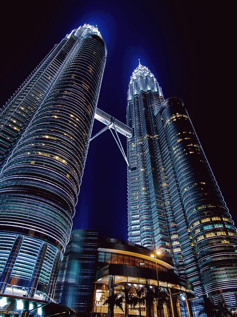 The Petronas Twin Towers lit up at night with the skybridge between them