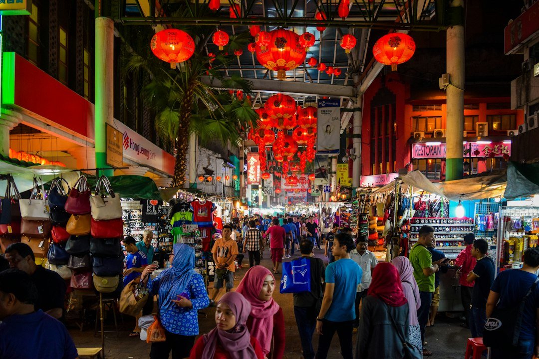 People exploring a lively Kuala Lumpur street at night